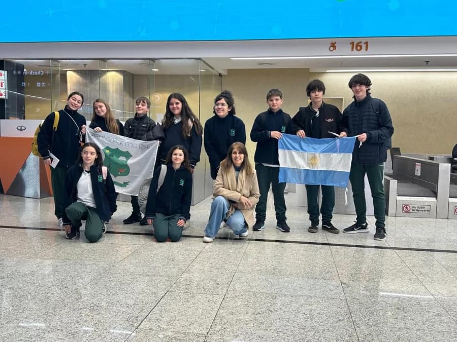 Delegación de Farmingdale College con el estandarte del colegio y la bandera argentina antes de viajar